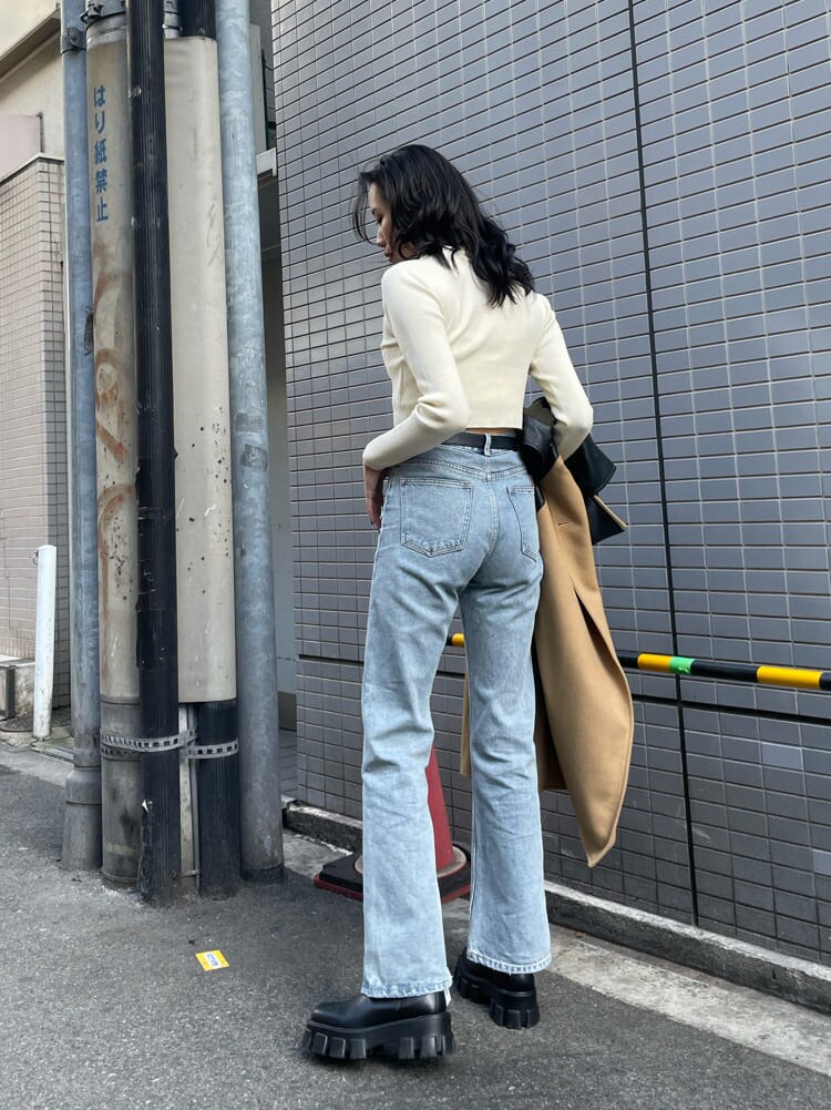 ブルー系のデニムパンツ、ブラック系のブーツ、ホワイト系のニット/セーターを着用したレディースの冬コーディネートの6枚目の写真