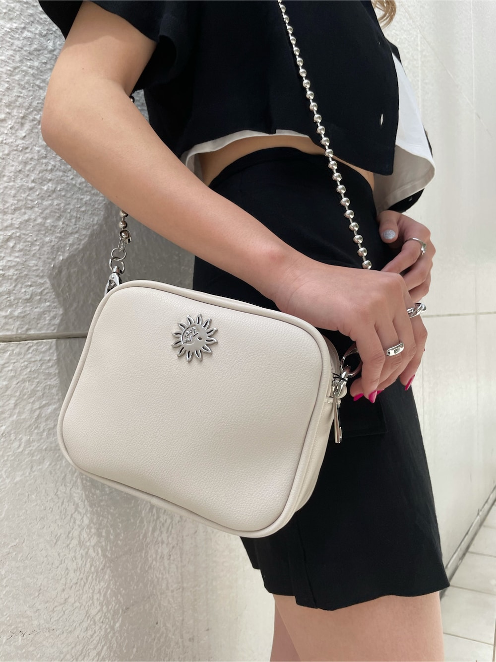 ブラック系のスカート、ブラック系のサンダル、シルバー系のネックレスを着用したレディースの春コーディネートの5枚目の写真