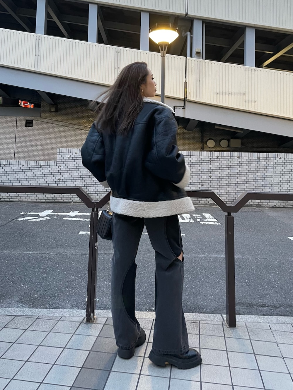 ブラック系のニット/セーター、ブラック系のデニムパンツ、ブラック系のブーツを着用したレディースの夏コーディネートの5枚目の写真