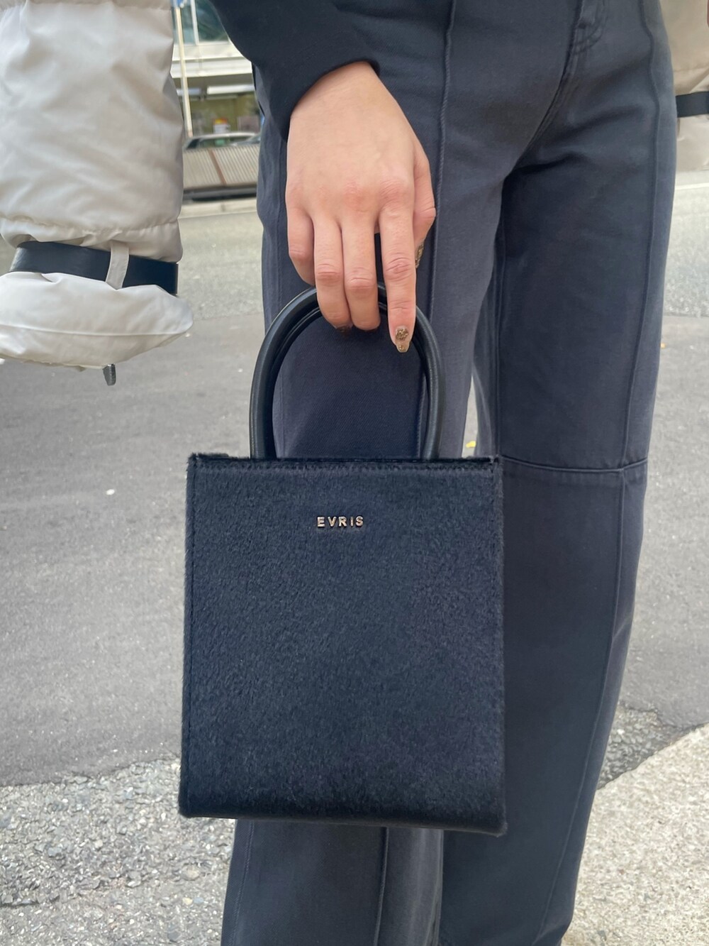 ホワイト系のダウンジャケット/コート、ブラック系のTシャツ/カットソー、ブラック系のショルダーバッグを着用したレディースの秋コーディネートの7枚目の写真