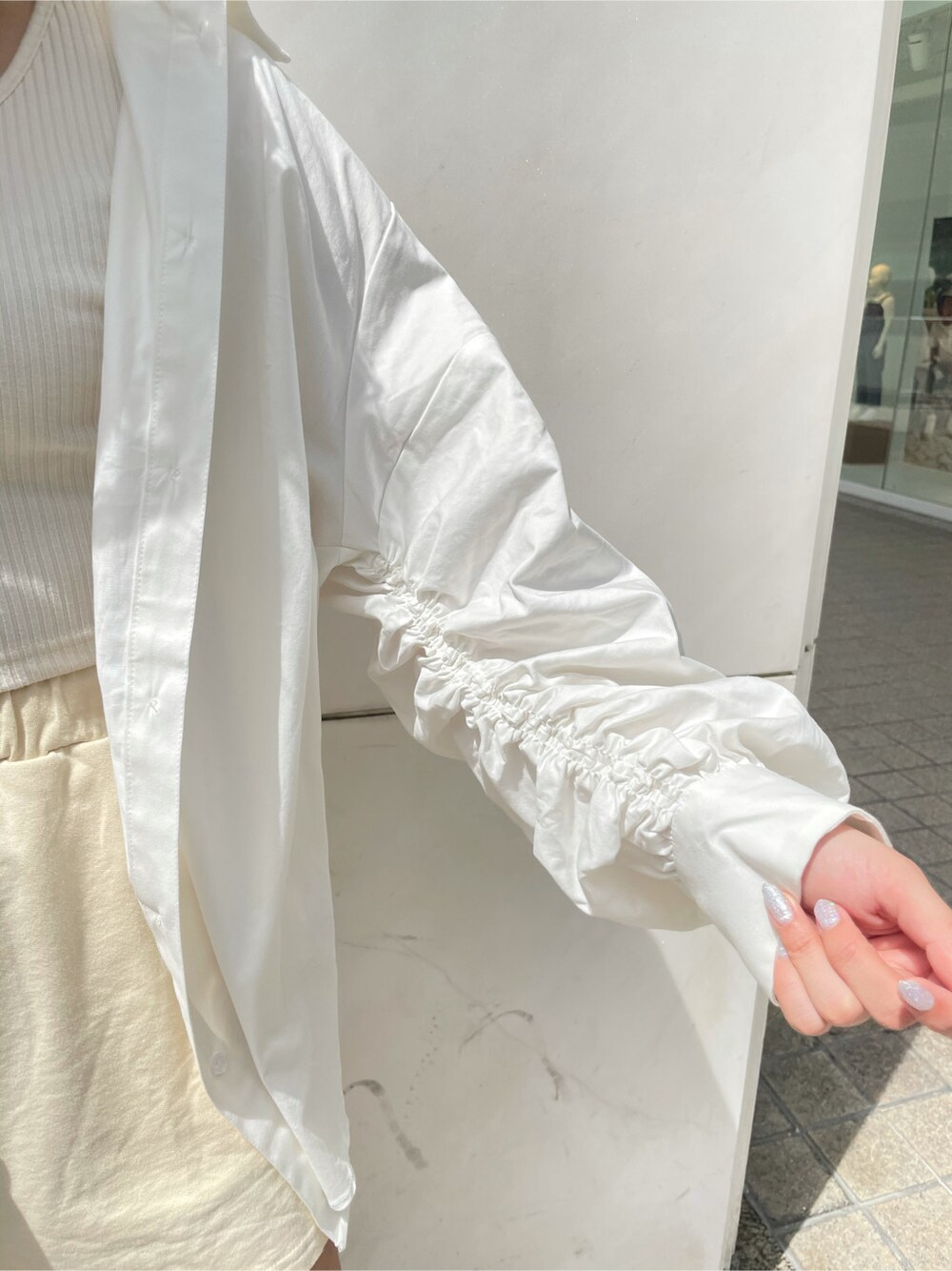 ホワイト系のシャツ/ブラウス、ブラック系のサンダル、シルバー系のネックレスを着用したレディースの春コーディネートの7枚目の写真