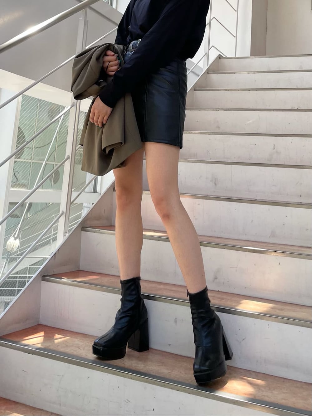 ベージュ系のテーラードジャケット、ブラック系のスカート、ブラック系のショルダーバッグを着用したレディースの秋コーディネートの3枚目の写真