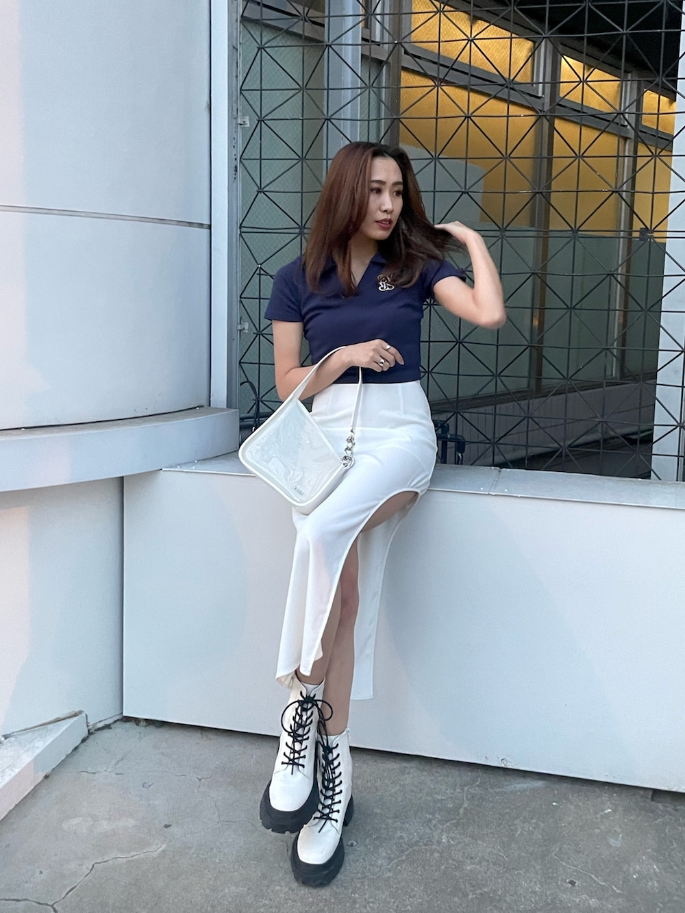 ホワイト系のブーツ、ホワイト系のスカート、ホワイト系のハンドバッグを着用したレディースの春コーディネートの4枚目の写真