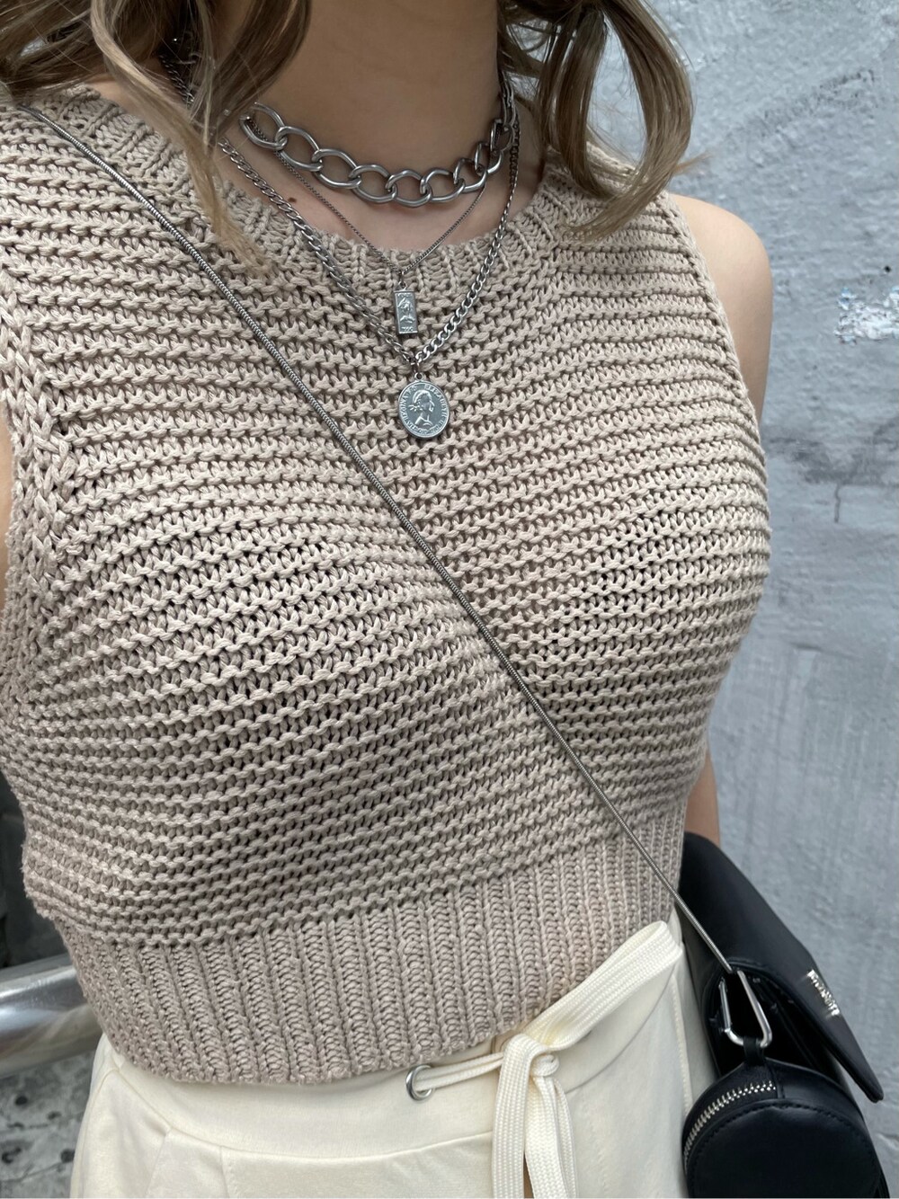 ホワイト系のスウェットパンツ、ベージュ系のタンクトップ、シルバー系のネックレスを着用したレディースの春コーディネートの6枚目の写真