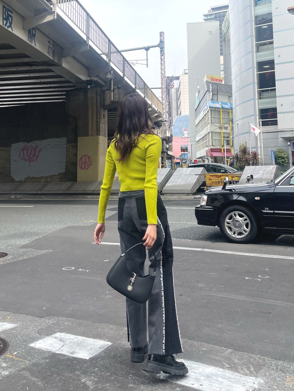 ブラック系のブーツ、ブラック系のハンドバッグ、ブラック系のニット/セーターを着用したレディースの秋コーディネートの2枚目の写真