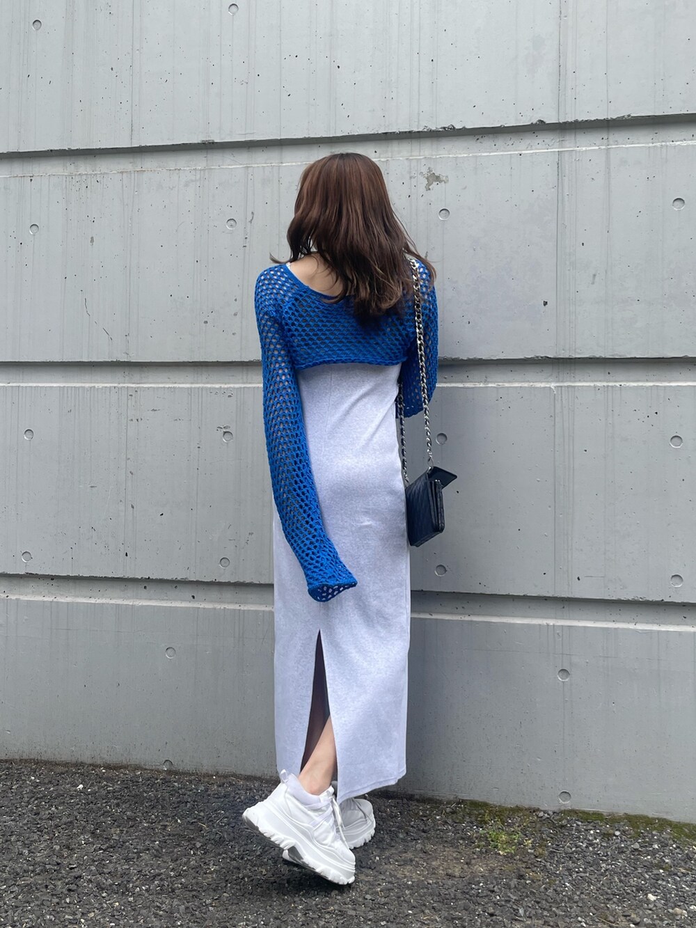 ブルー系のニット/セーター、ブラック系のショルダーバッグ、グレー系のワンピースを着用したレディースの春コーディネートの2枚目の写真