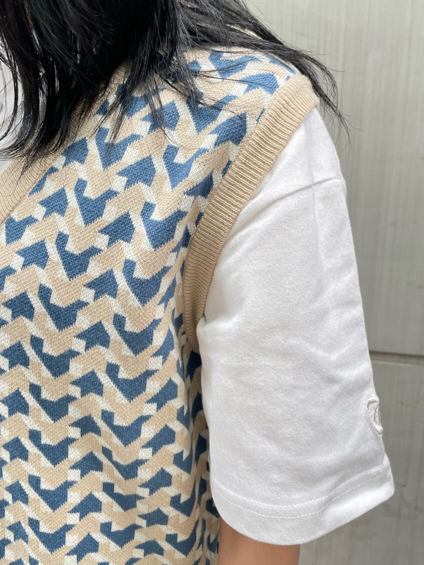 ブラック系のブーツ、ベージュ系のニット/セーター、ホワイト系のTシャツ/カットソーを着用したレディースの春コーディネートの8枚目の写真