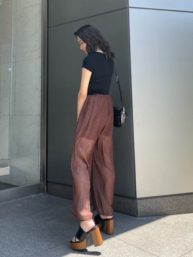 ブラウン系のその他パンツ、ブラック系のサンダル、ブラック系のTシャツ/カットソーを着用したレディースの夏コーディネートの2枚目の写真