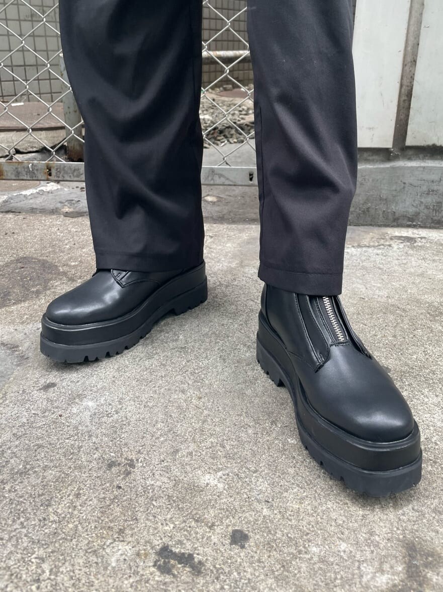 ブラック系のボディバッグ/ウエストポーチ、ブラック系のブーツ、ホワイト系のTシャツ/カットソーを着用したレディースの冬コーディネートの6枚目の写真