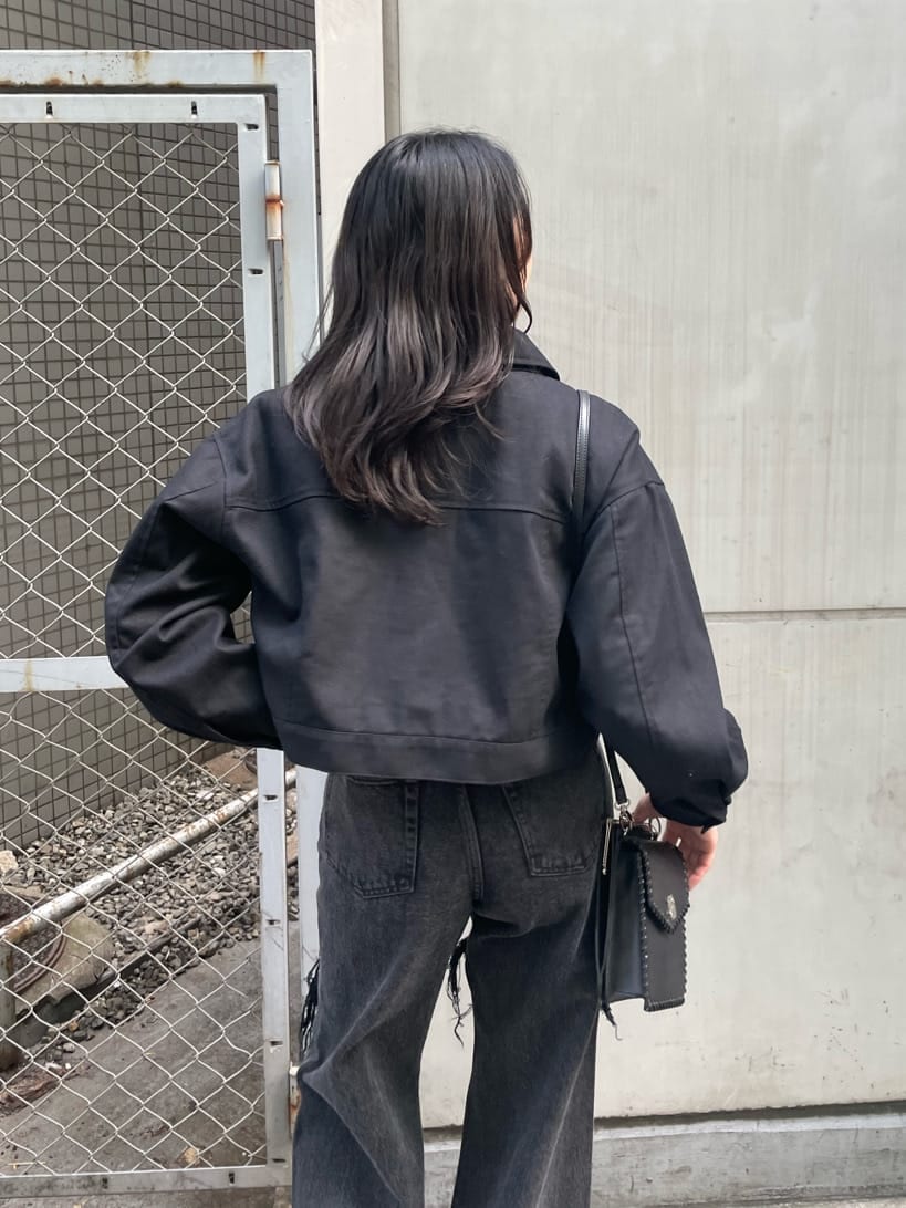 ブラック系のショルダーバッグ、ブラック系のデニムパンツ、ブラック系のブーツを着用したレディースの春コーディネートの7枚目の写真