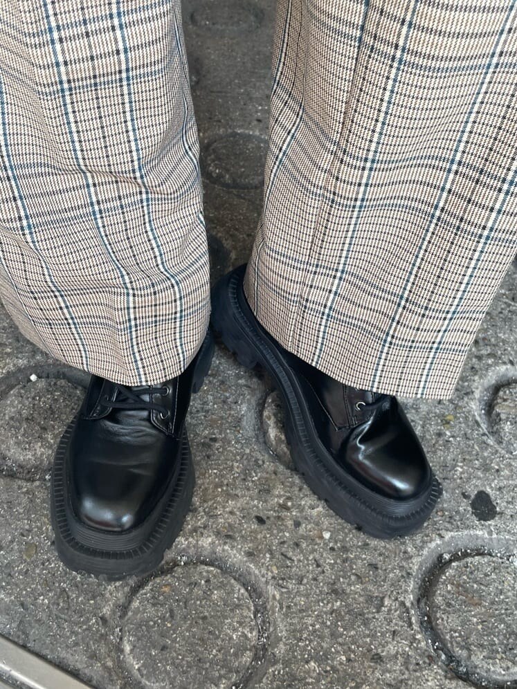 ブラック系のブーツ、その他のその他パンツ、ブラック系のハンドバッグを着用したレディースの秋コーディネートの8枚目の写真