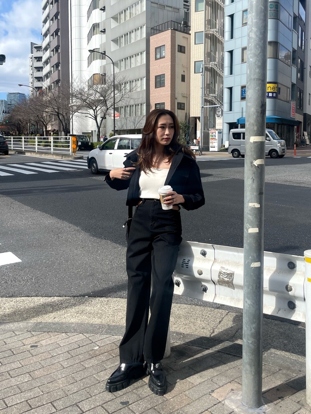 ブラック系のミリタリージャケット、ホワイト系のニット/セーター、ブラック系のデニムパンツを着用したレディースの春コーディネートの2枚目の写真