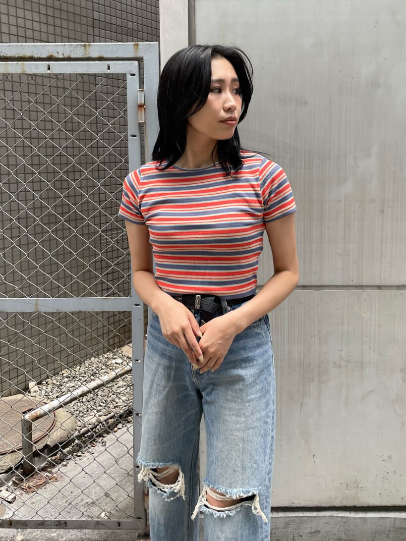 ブラック系のサンダル、ブルー系のデニムパンツ、オレンジ系のTシャツ/カットソーを着用したレディースの夏コーディネートの3枚目の写真