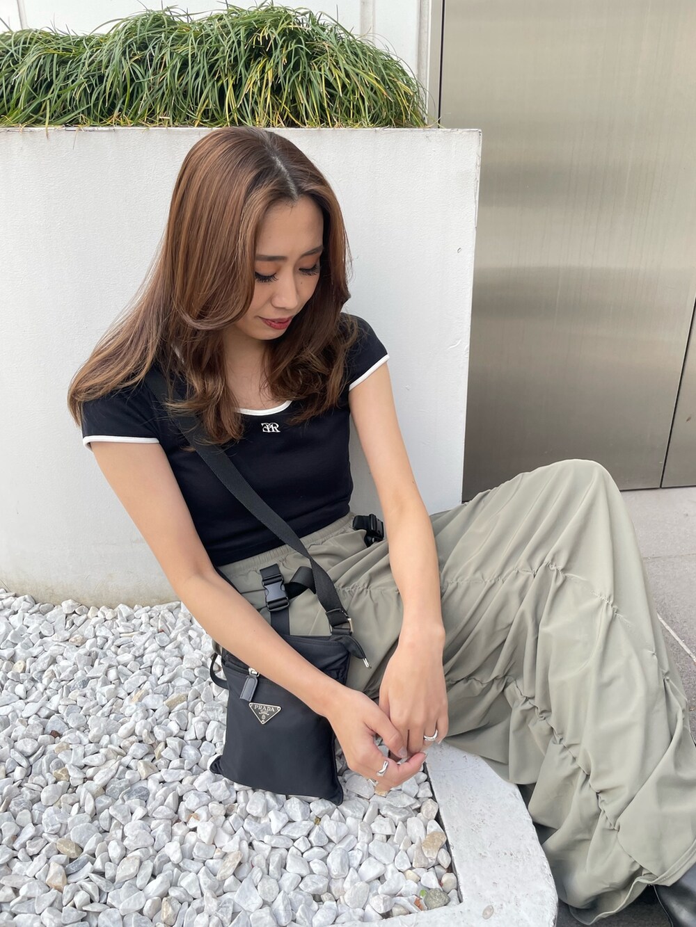 ブラック系のTシャツ/カットソー、グリーン系のスカート、ブラック系のブーツを着用したレディースの春コーディネートの2枚目の写真