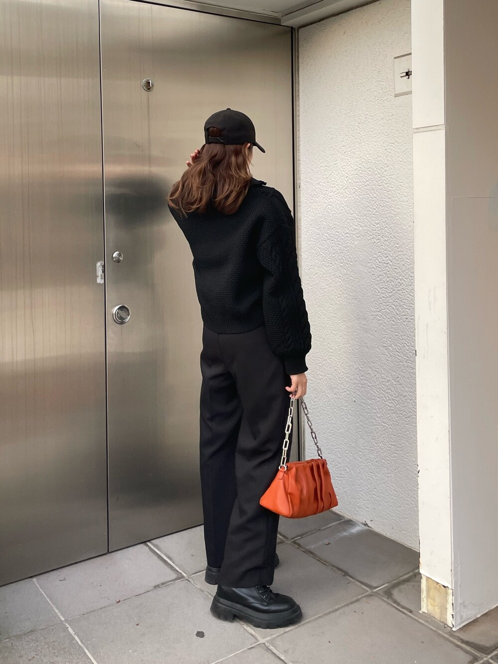 ブラック系のニット/セーター、ブラック系のスラックス、ブラック系のブーツを着用したレディースの冬コーディネートの5枚目の写真