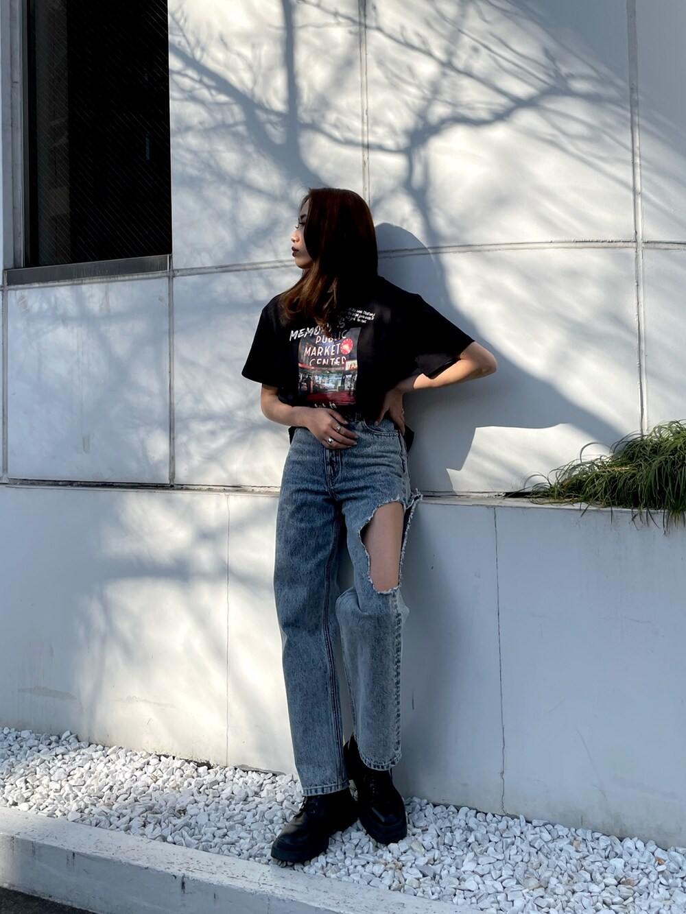 ブラック系のTシャツ/カットソー、ブルー系のデニムパンツ、ブラック系のブーツを着用したレディースの春コーディネートの2枚目の写真
