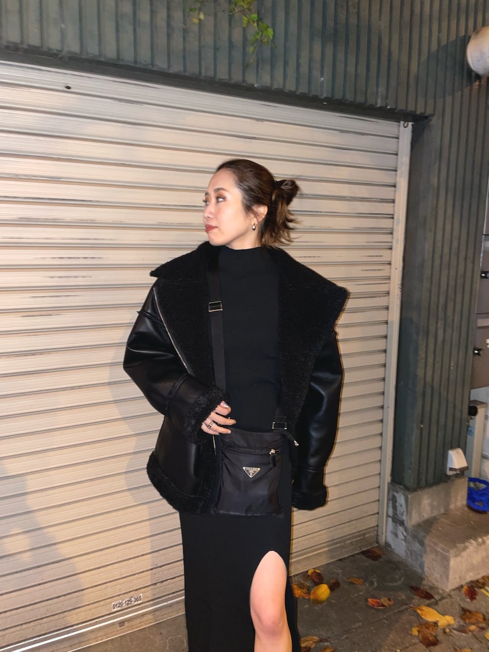 ブラック系のブルゾン、ブラック系のワンピース、ブラック系のブーツを着用したレディースの冬コーディネートの2枚目の写真