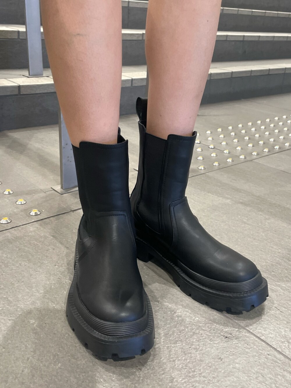 ホワイト系のスウェット、ブラック系のハンドバッグ、ブラック系のデニムスカートを着用したレディースの秋コーディネートの9枚目の写真