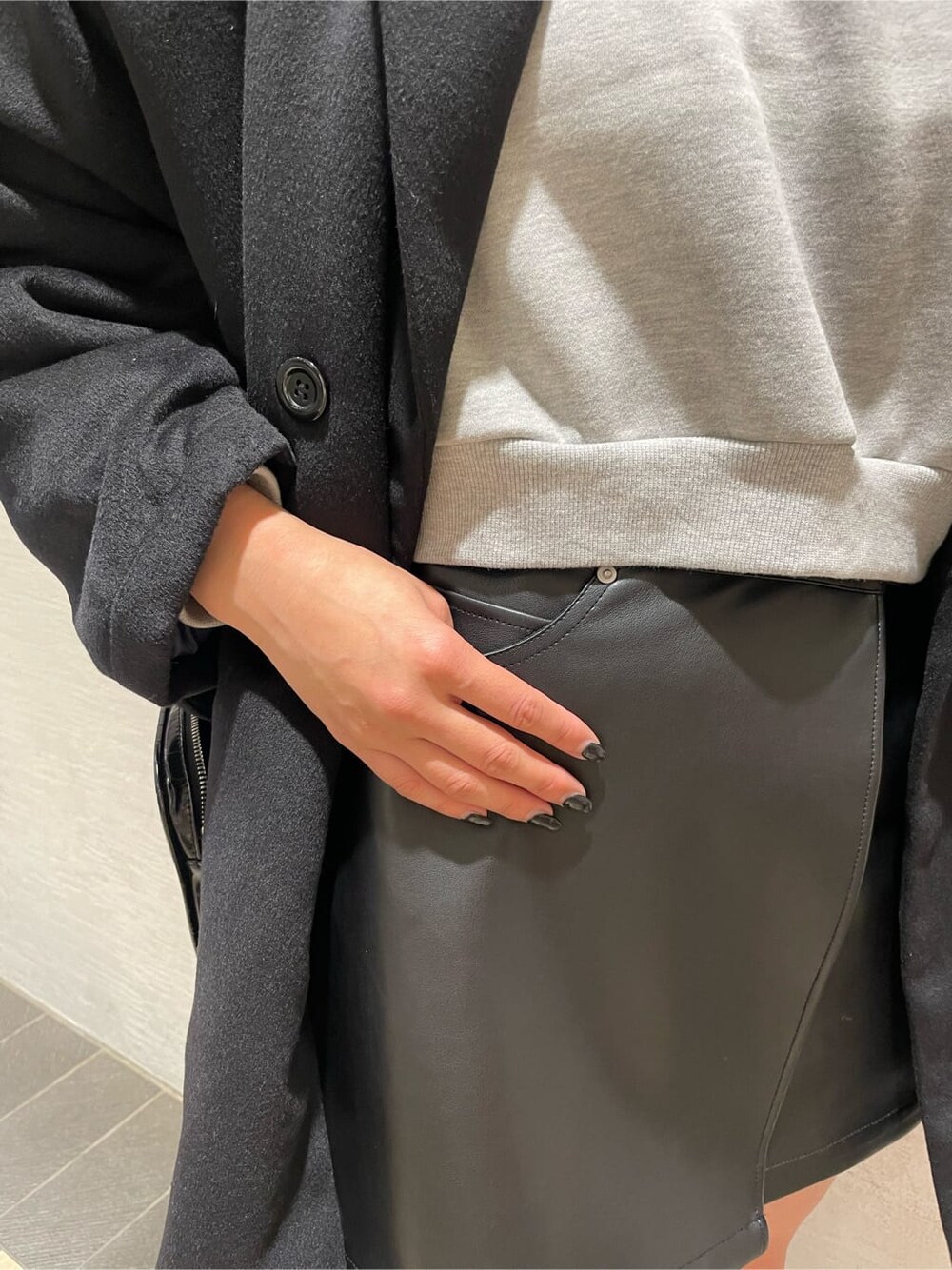 ブラック系のその他アウター、ブラック系のショルダーバッグ、ブラック系のスカートを着用したレディースの冬コーディネートの7枚目の写真