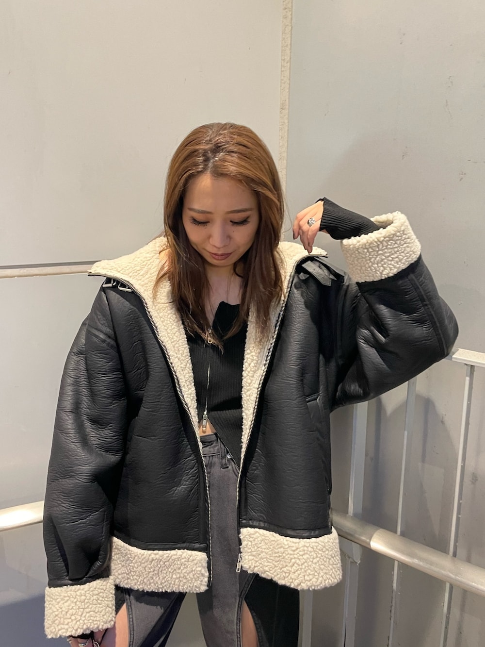 ブラック系のニット/セーター、ブラック系のデニムパンツ、ブラック系のブーツを着用したレディースの夏コーディネートの4枚目の写真