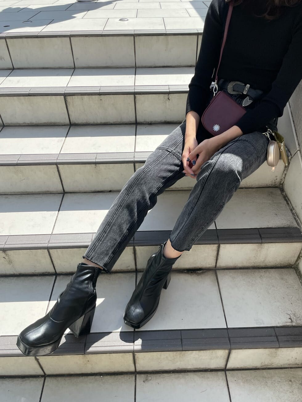 レッド系のショルダーバッグ、ブラック系のデニムパンツ、ブラック系のニット/セーターを着用したレディースの秋コーディネートの6枚目の写真