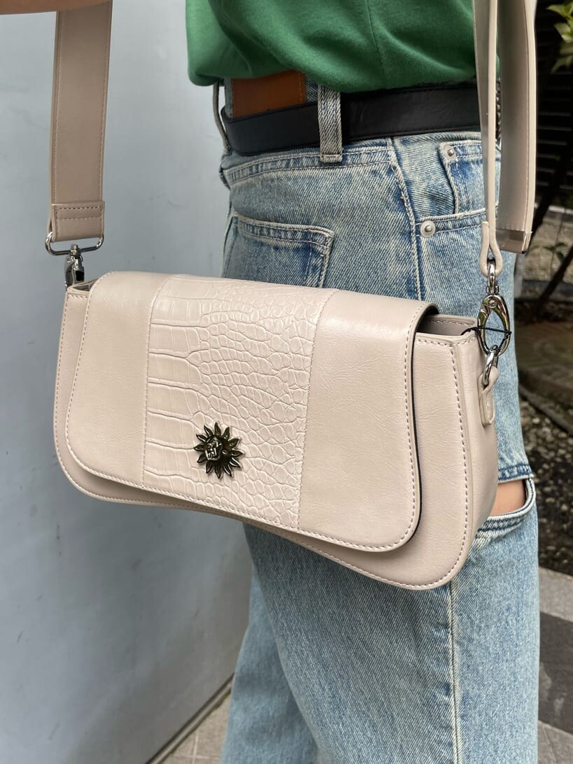 グリーン系のTシャツ/カットソー、ホワイト系のショルダーバッグ、ブルー系のデニムパンツを着用したレディースの春コーディネートの7枚目の写真