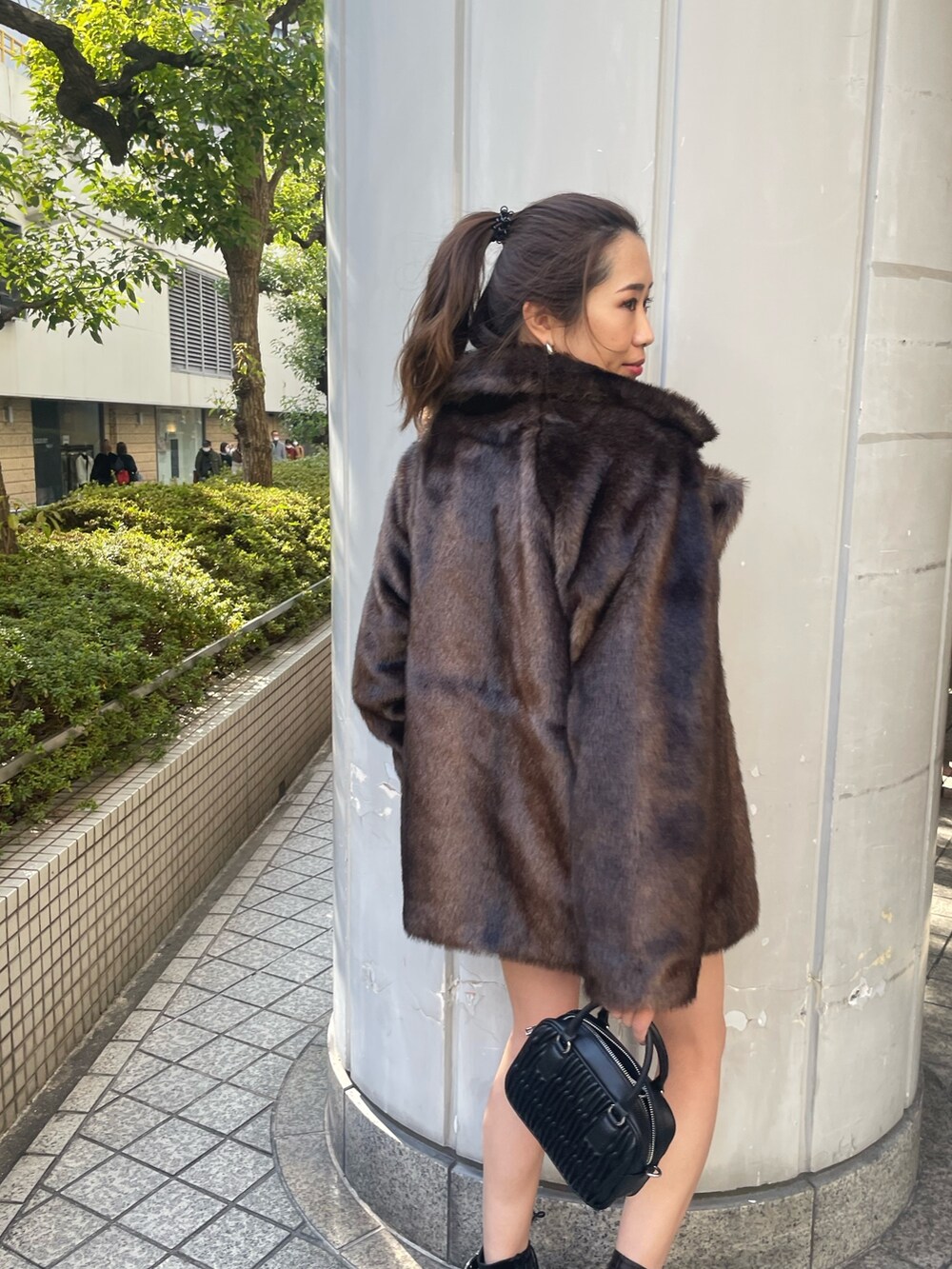 グレー系のスウェット、ブラック系のショルダーバッグ、ブラック系のブーツを着用したレディースの冬コーディネートの5枚目の写真