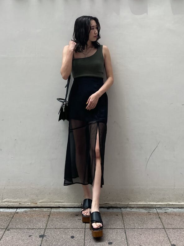 ブラック系のスカート、ブラック系のサンダル、ベージュ系のTシャツ/カットソーを着用したレディースの夏コーディネートの2枚目の写真