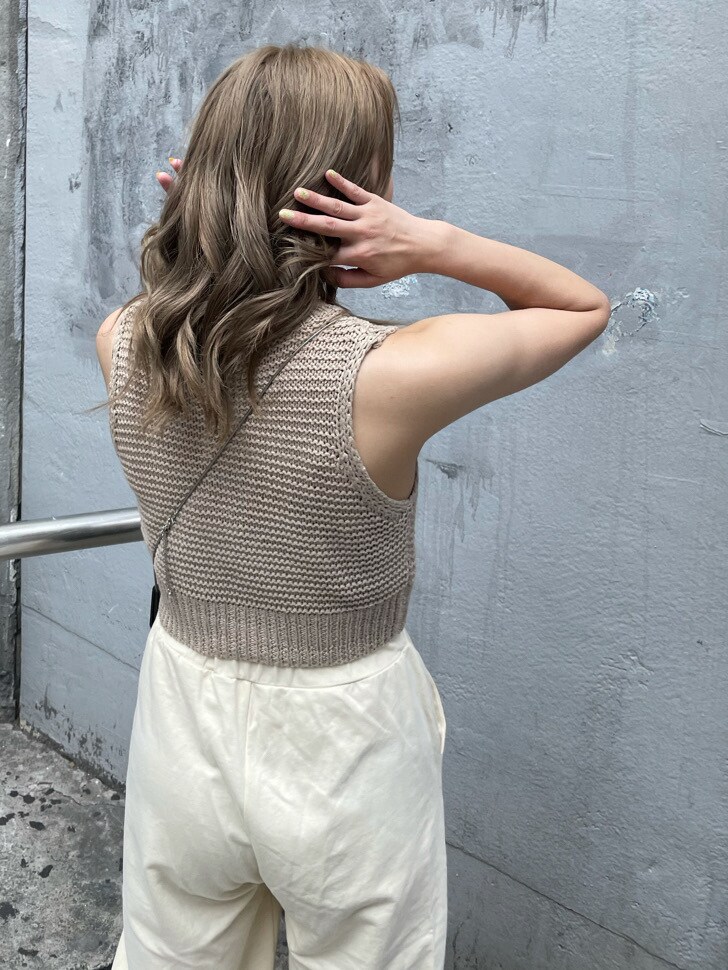 ホワイト系のスウェットパンツ、ベージュ系のタンクトップ、シルバー系のネックレスを着用したレディースの春コーディネートの4枚目の写真