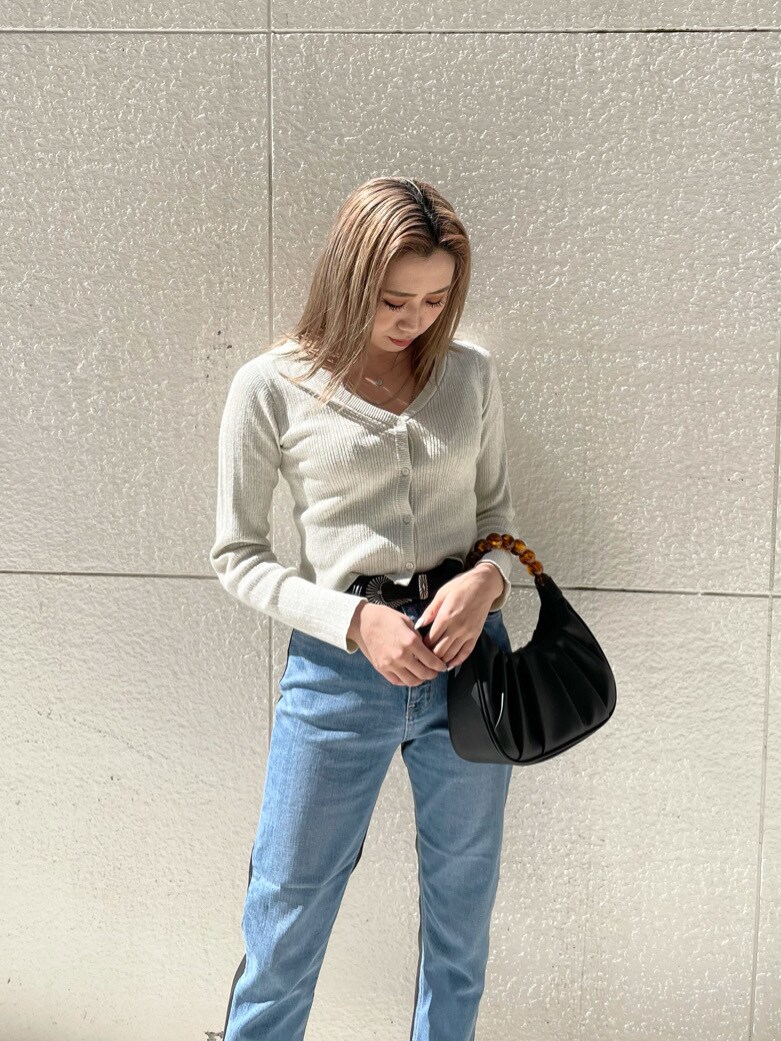 ブラック系のパンプス、ブルー系のデニムパンツ、ブラック系のハンドバッグを着用したレディースの春コーディネートの4枚目の写真