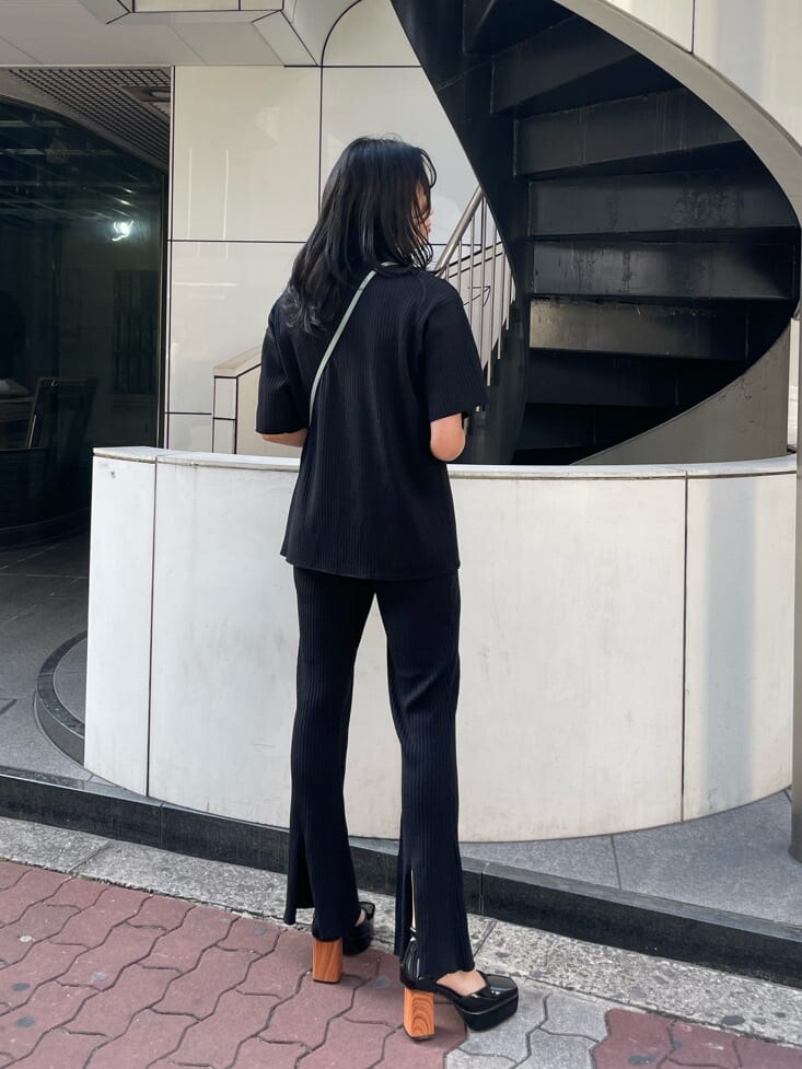 ブラック系のパンプス、グリーン系のショルダーバッグ、ブラック系のその他パンツを着用したレディースの春コーディネートの2枚目の写真