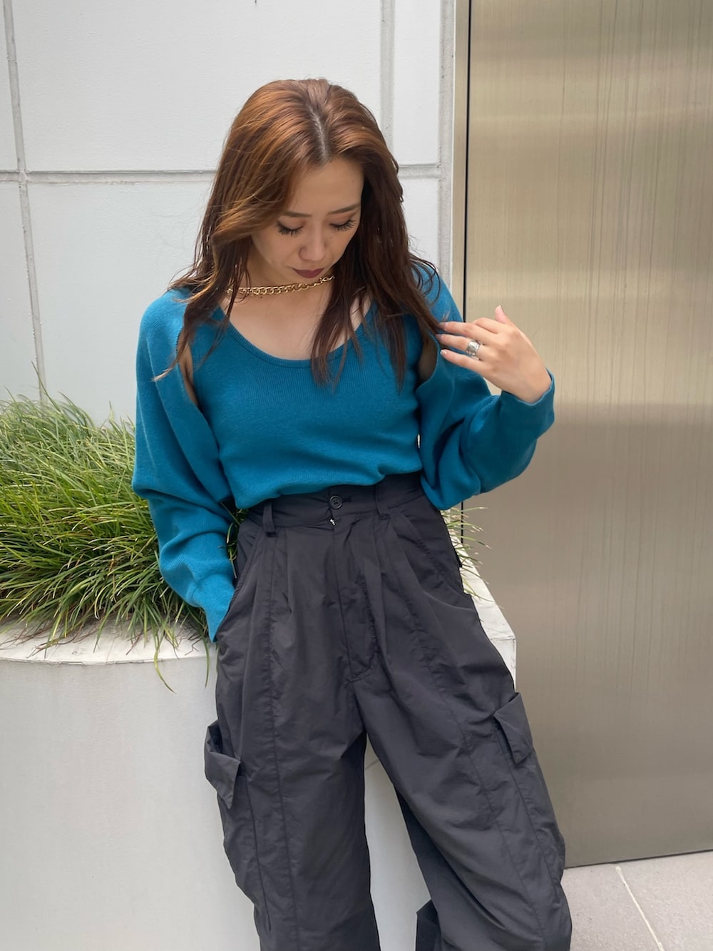 ブラック系のカーゴパンツ、ホワイト系のスニーカー、ブルー系のニット/セーターを着用したレディースの夏コーディネートの4枚目の写真