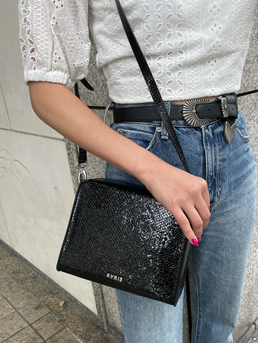 ブラック系のキャミソール、ホワイト系のシャツ/ブラウス、ブルー系のデニムパンツを着用したレディースの春コーディネートの5枚目の写真