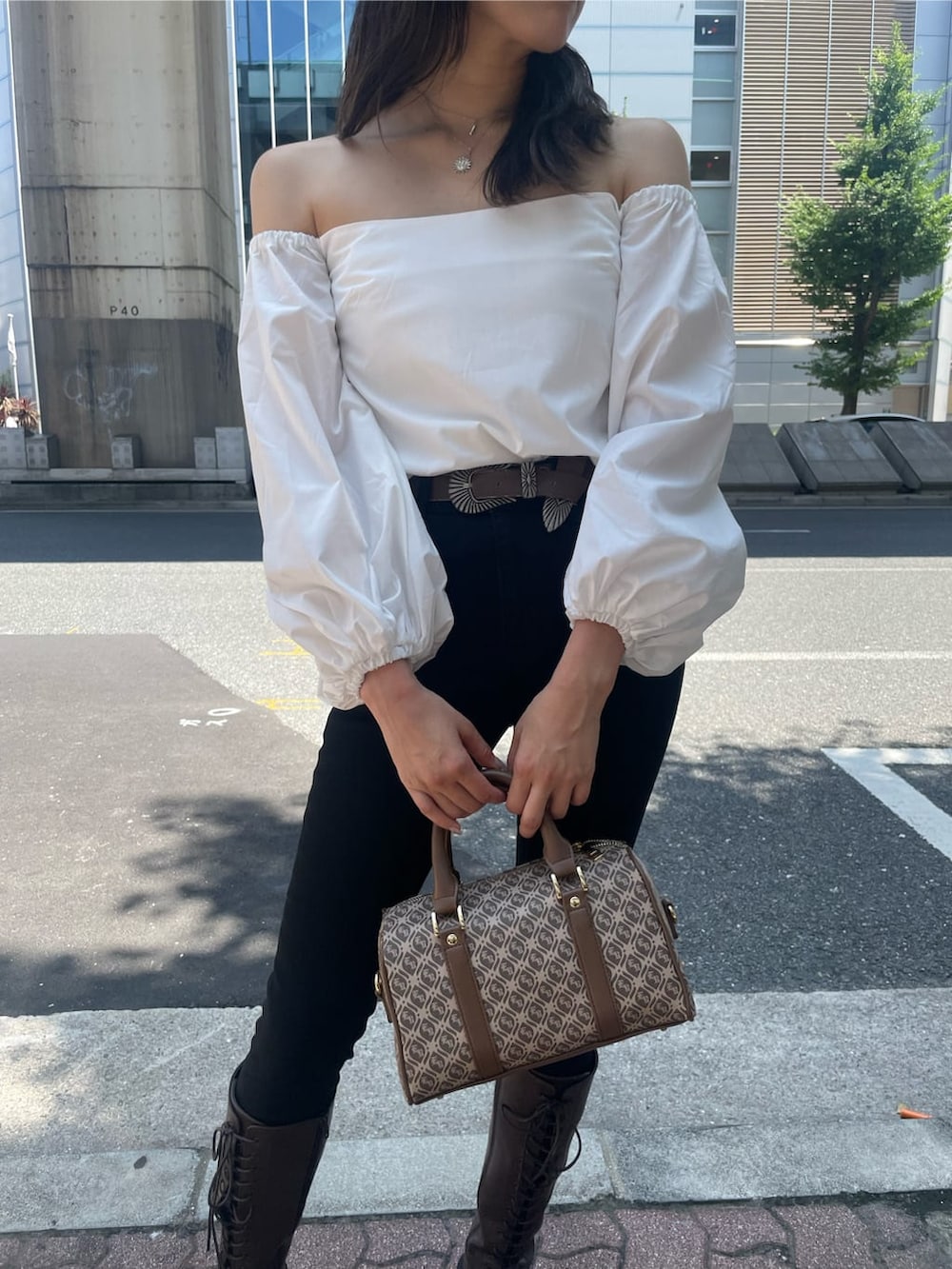 ブラウン系のブーツ、ブラウン系のボストンバッグ、ホワイト系のシャツ/ブラウスを着用したレディースの秋コーディネートの5枚目の写真