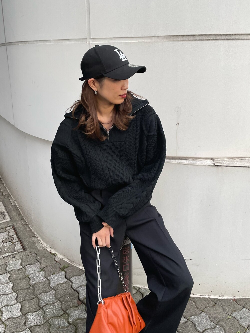 ブラック系のニット/セーター、ブラック系のスラックス、ブラック系のブーツを着用したレディースの冬コーディネートの2枚目の写真