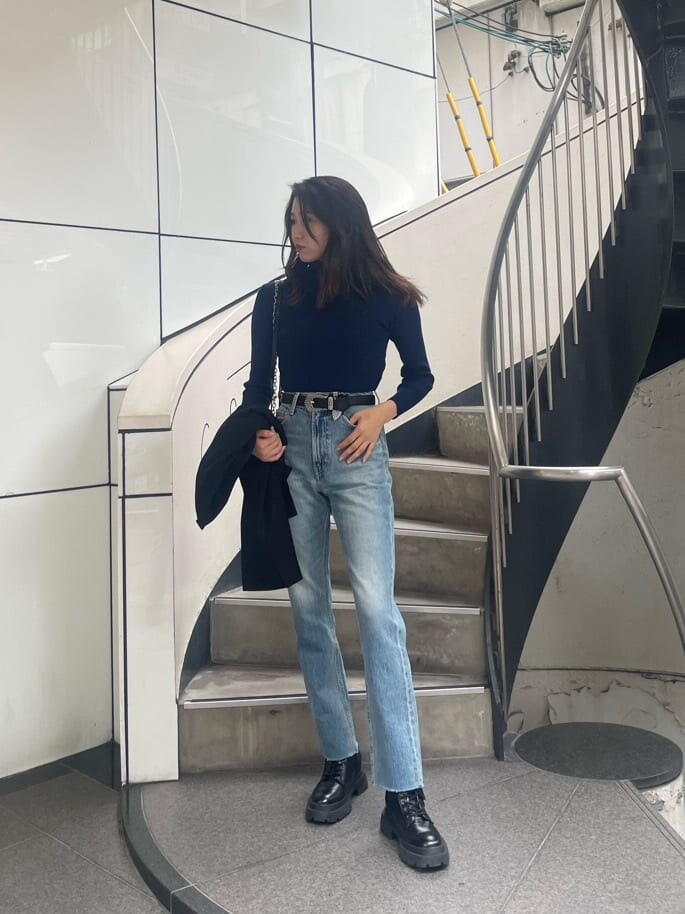 ブラック系のブーツ、ブラック系のテーラードジャケット、ブラック系のハンドバッグを着用したレディースの秋コーディネートの2枚目の写真