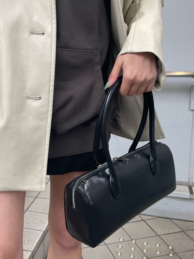 ホワイト系のテーラードジャケット、ブラック系のスカート、ブラック系のブーツを着用したレディースの冬コーディネートの9枚目の写真