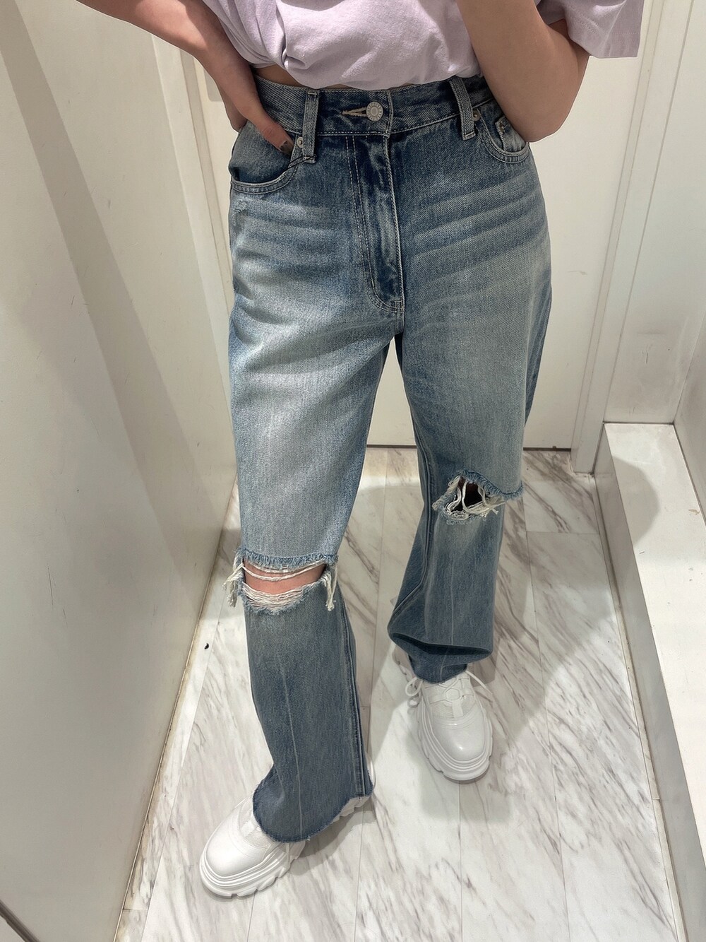 パープル系のTシャツ/カットソー、ブルー系のデニムパンツ、ホワイト系のスニーカーを着用したレディースの春コーディネートの4枚目の写真