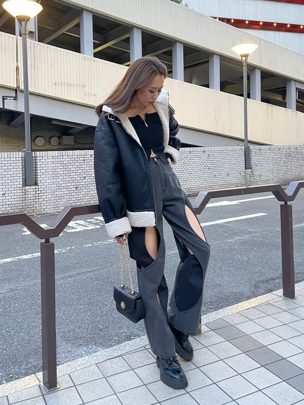 ブラック系のニット/セーター、ブラック系のデニムパンツ、ブラック系のブーツを着用したレディースの夏コーディネートの2枚目の写真