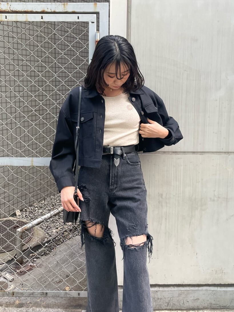 ブラック系のショルダーバッグ、ブラック系のデニムパンツ、ブラック系のブーツを着用したレディースの春コーディネートの5枚目の写真