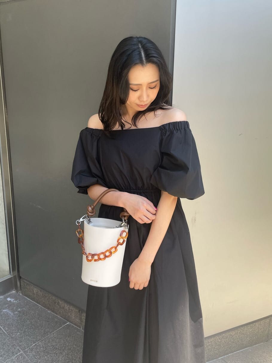 ブラック系のワンピース、ホワイト系のサンダル、ホワイト系のショルダーバッグを着用したレディースの春コーディネートの4枚目の写真