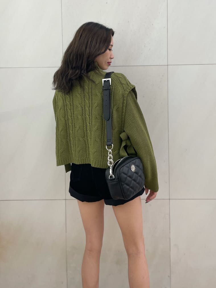 ベージュ系のニット/セーター、ブラック系のブーツ、ブラック系のショルダーバッグを着用したレディースの秋コーディネートの3枚目の写真