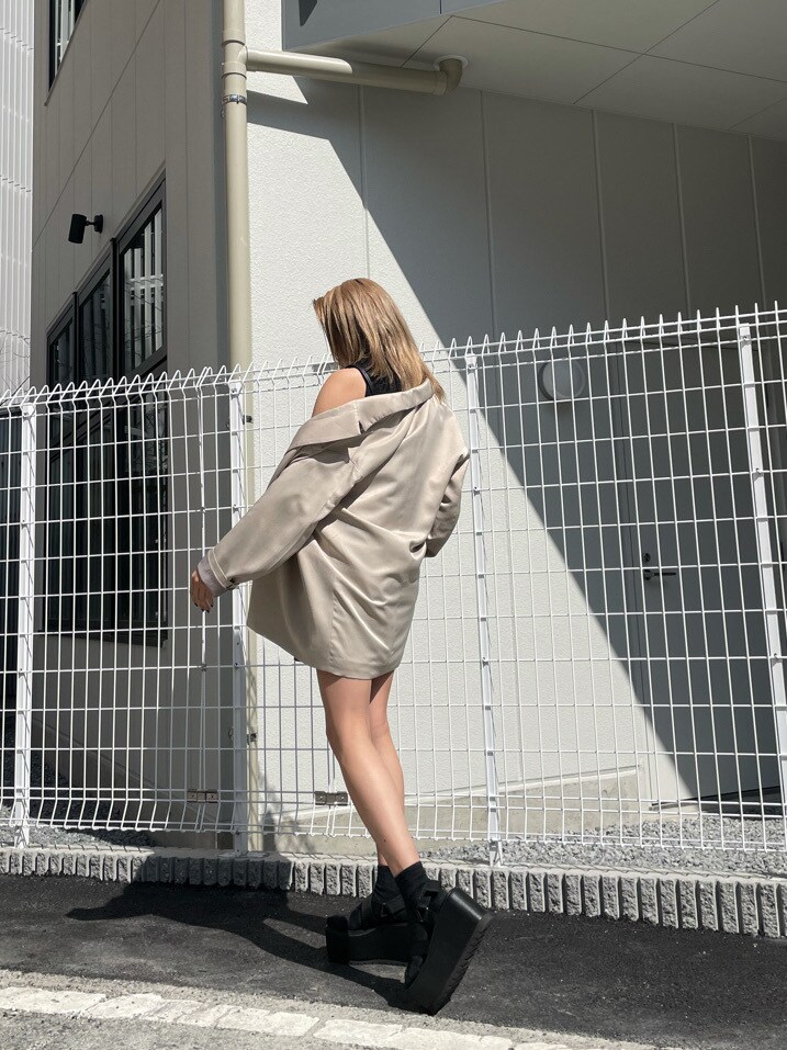 グレー系のテーラードジャケット、ブラック系のタンクトップ、ブラック系のサンダルを着用したレディースの春コーディネートの5枚目の写真