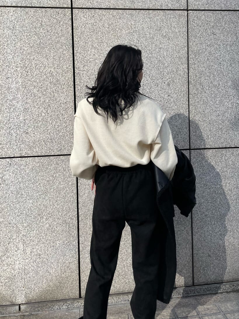 ブラック系のブーツ、ホワイト系のスウェット、ブラック系のその他アウターを着用したレディースの冬コーディネートの6枚目の写真