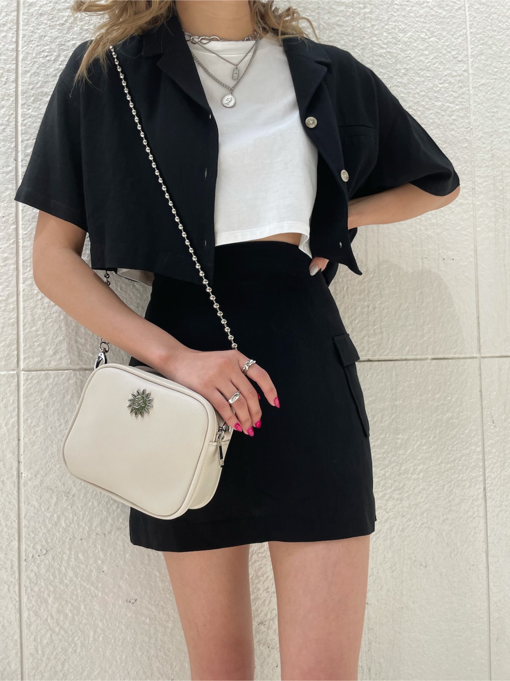 ブラック系のスカート、ブラック系のサンダル、シルバー系のネックレスを着用したレディースの春コーディネートの3枚目の写真