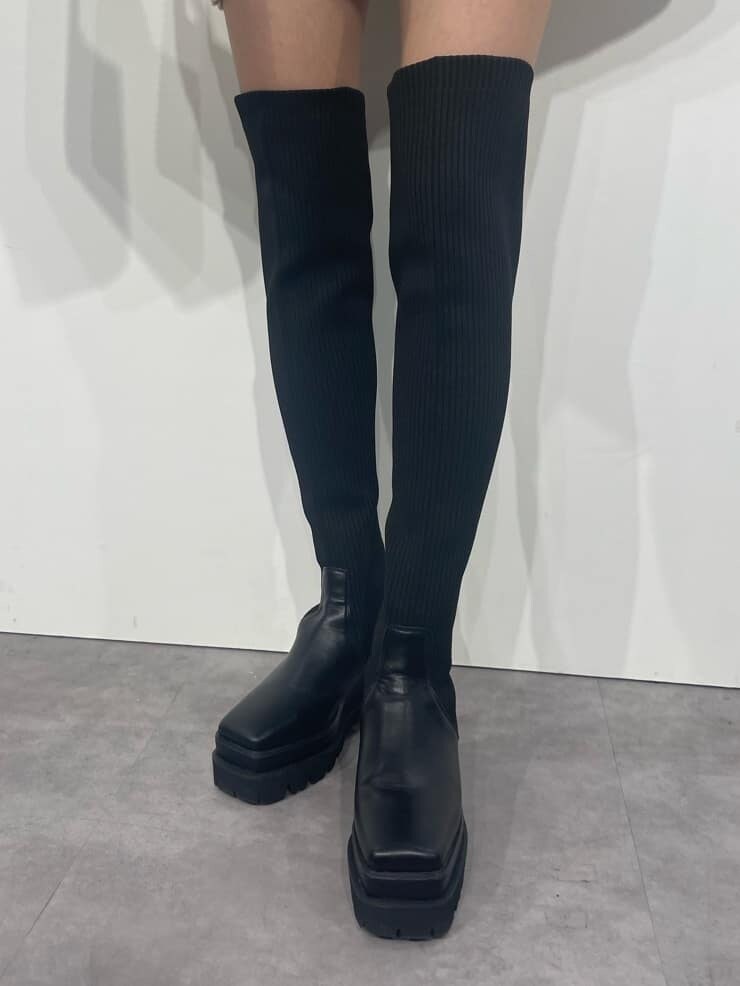 ブラック系のショルダーバッグ、ホワイト系のニット/セーター、ブラック系のブーツを着用したレディースの秋コーディネートの7枚目の写真