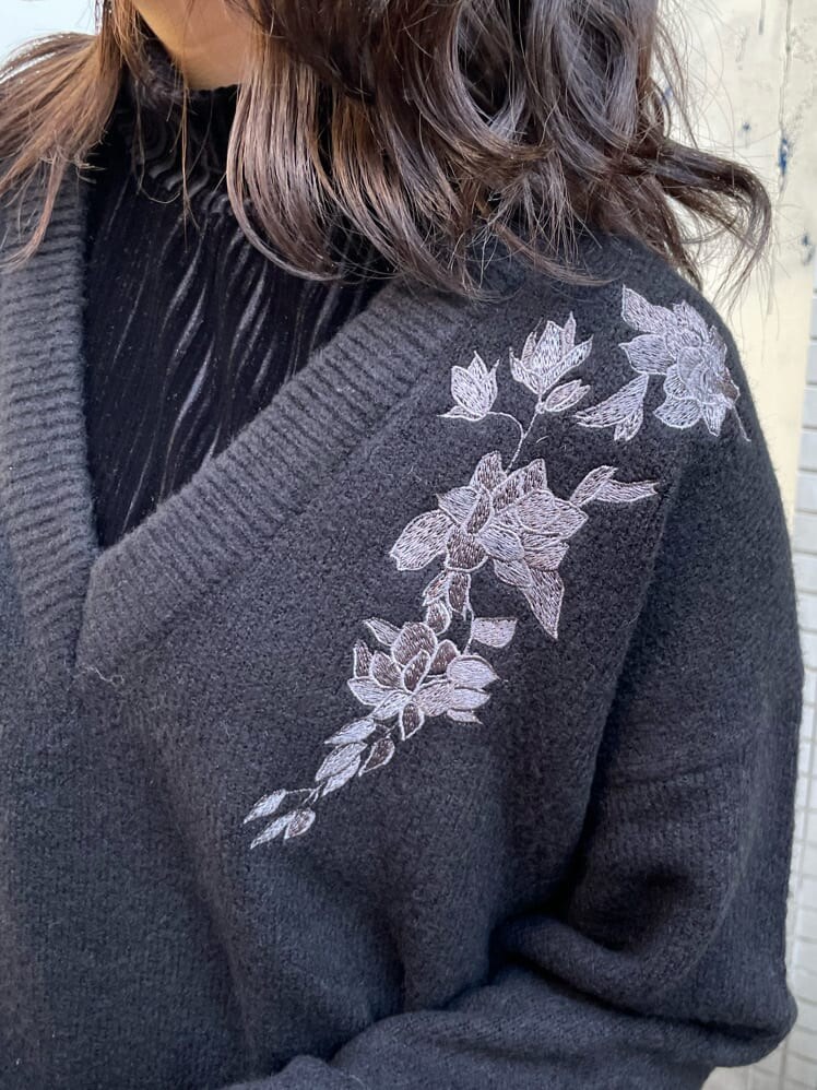 ブラック系のハンドバッグ、ブラック系のTシャツ/カットソー、ブラック系のブーツを着用したレディースの冬コーディネートの2枚目の写真