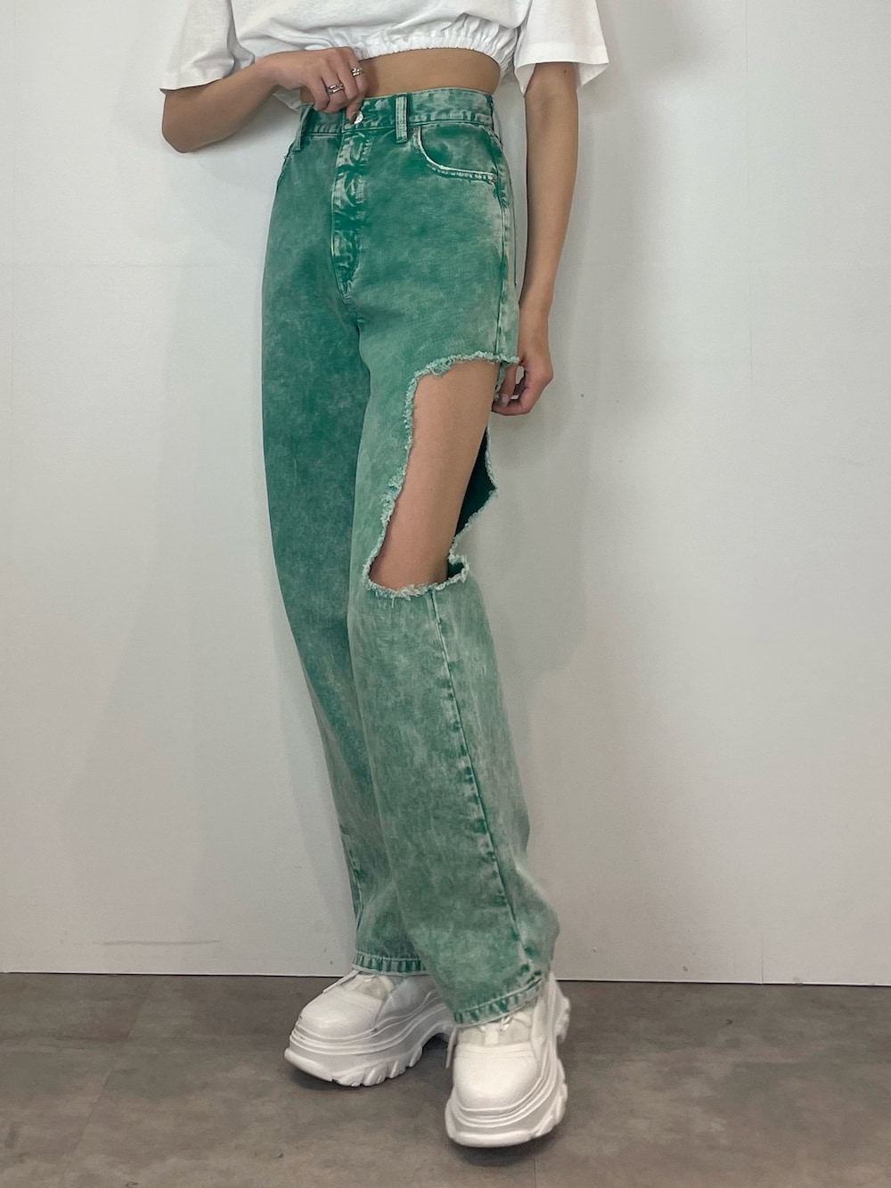 グリーン系のデニムパンツ、ホワイト系のスニーカー、ホワイト系のTシャツ/カットソーを着用したレディースの春コーディネートの4枚目の写真