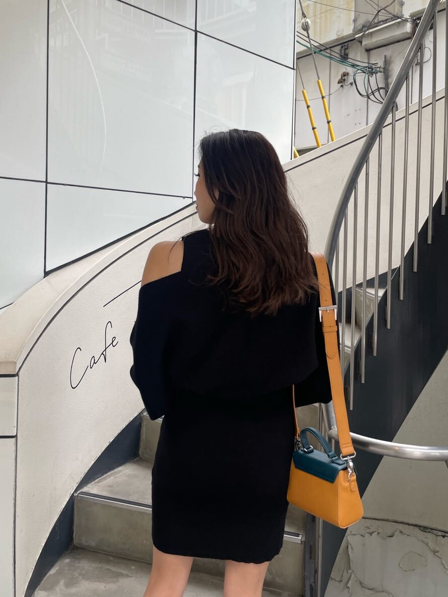 ブラック系のワンピース、ブラック系のブーツ、イエロー系のショルダーバッグを着用したレディースの秋コーディネートの4枚目の写真