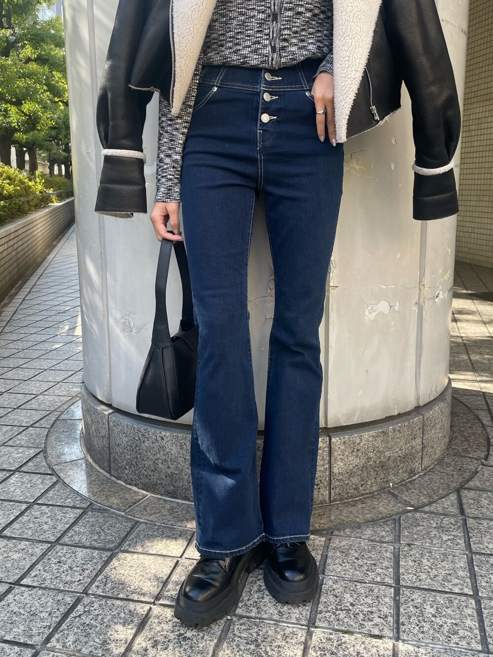 ブラック系のブルゾン、ブラック系のニット/セーター、ブルー系のデニムパンツを着用したレディースの冬コーディネートの8枚目の写真